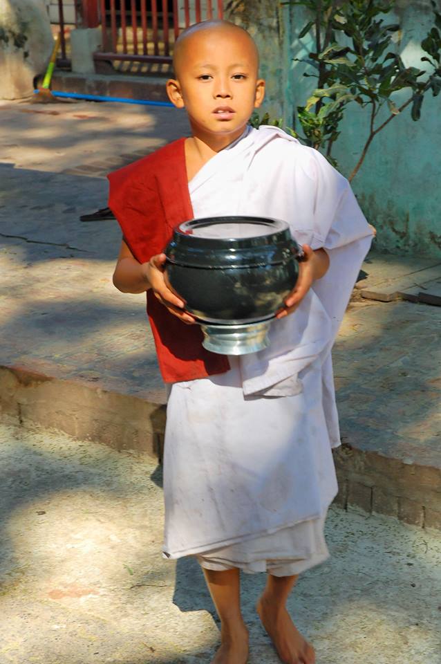 Young monk with his lunch. Amarapura, Mandalay region, Myanmar