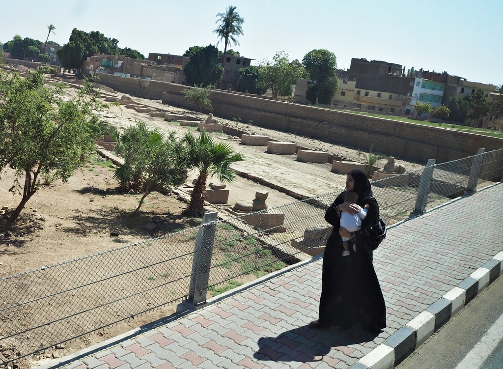 Жена минаваща до алеята на сфинксовете в Карнак, Египет